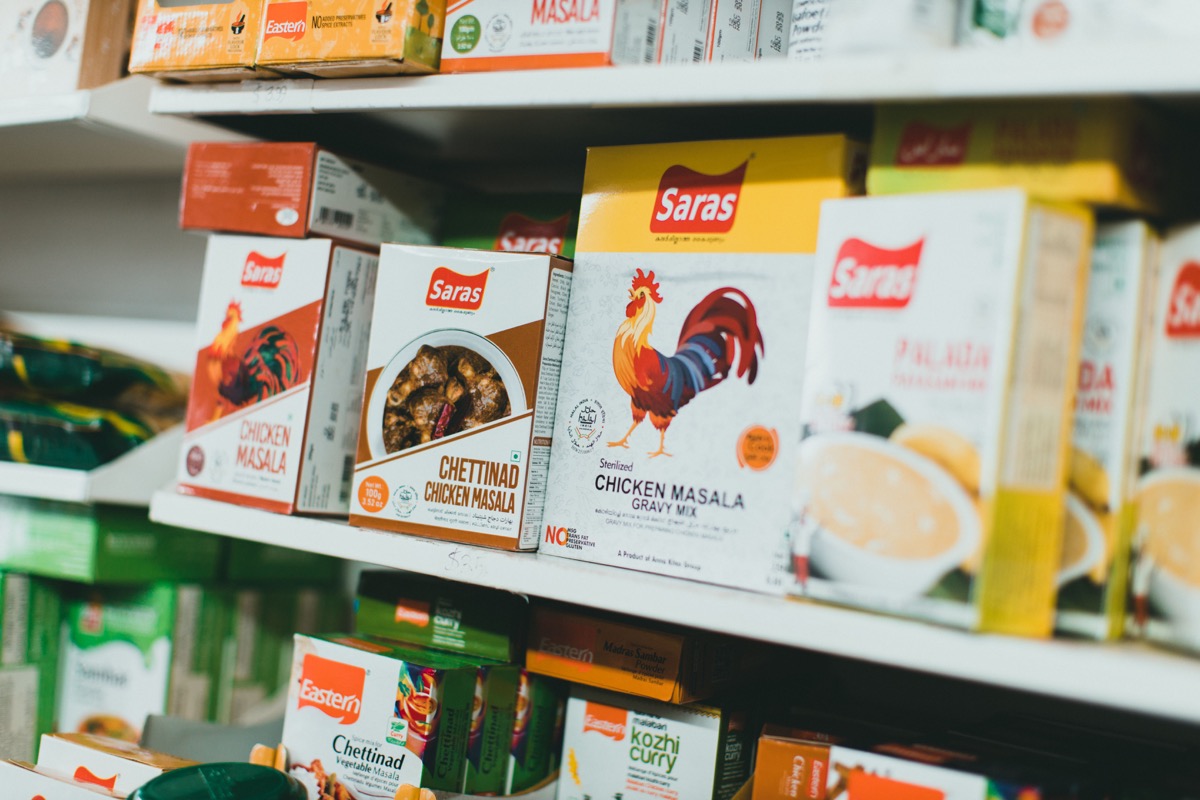 Assortment of Indian spice mixes on a grocery store shelf, featuring halal label on packaging.